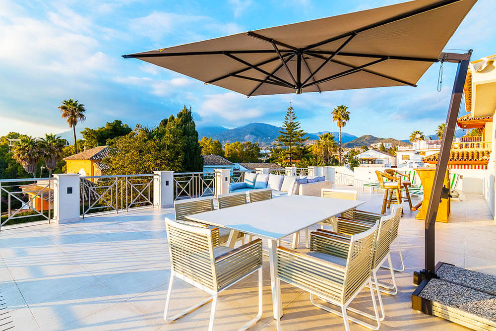 Stylish rooftop dinning in Marbella with sunshade and mountain views