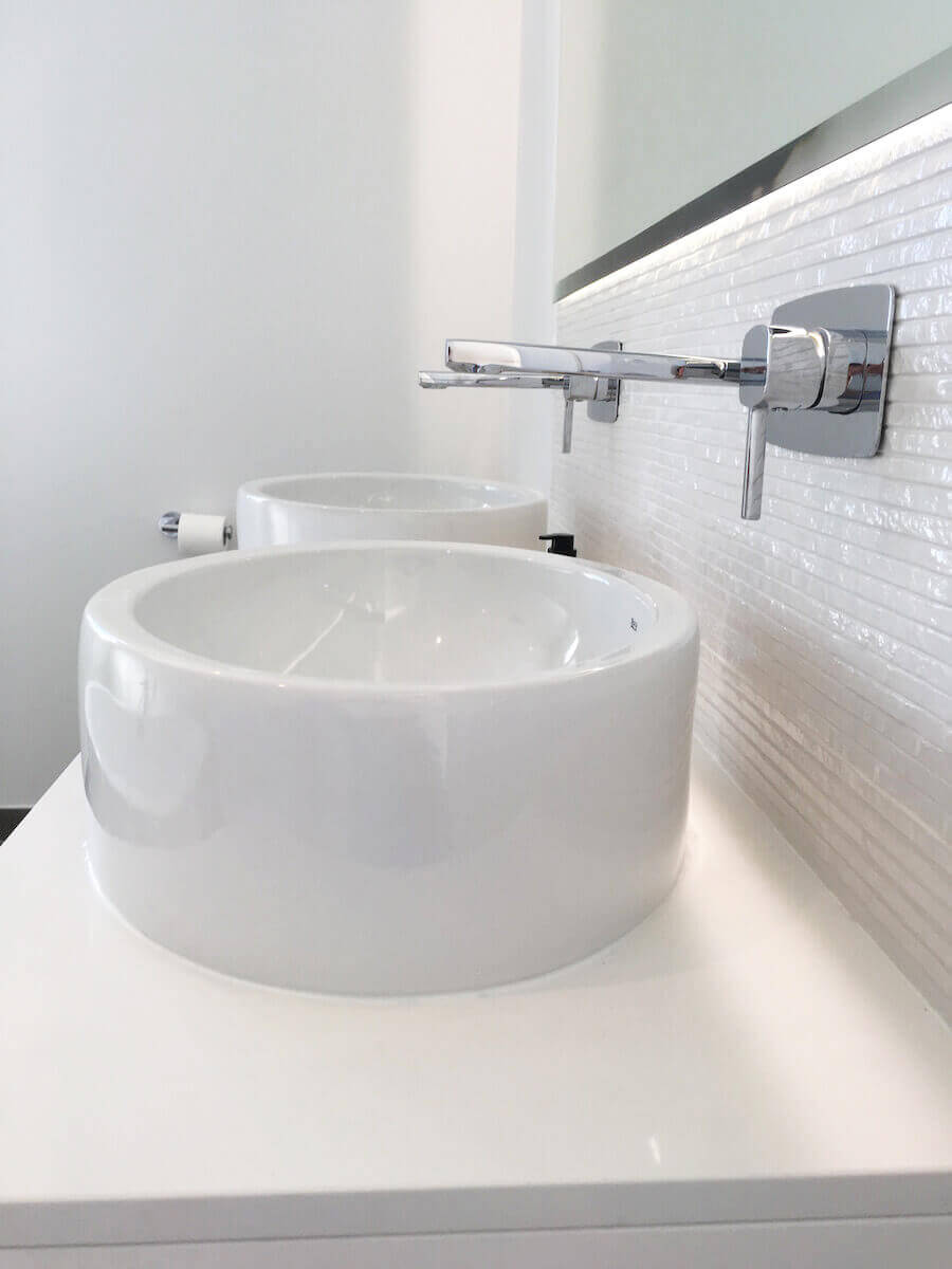 Close up of sinks in white bathroom