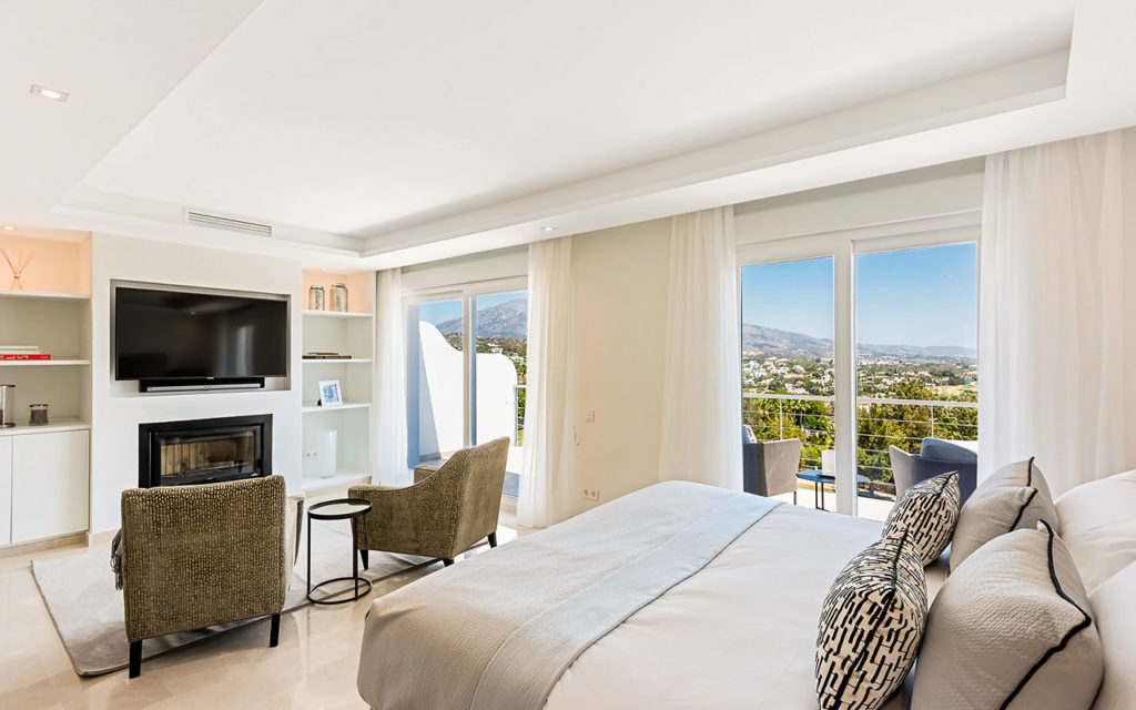 Stylish bedroom with built in fireplace overlooking mountains in La Quinta, Marbella