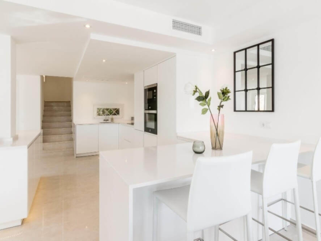 Stylish modern white kitchen with breakfast bar designed and built by ProMas in Marbella