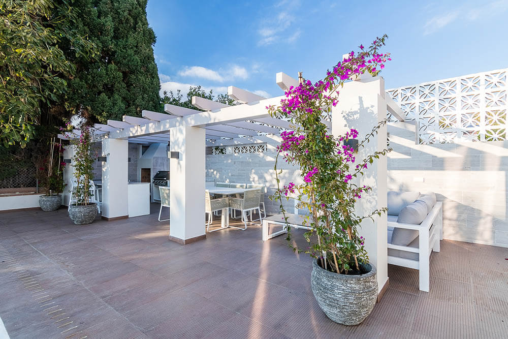 Outdoor kitchen with pergola dinning and climbing boganville vine