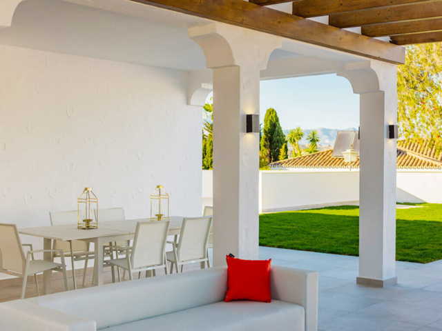 Stylish white outdoor living and dinning space with pergola looking to the mountains in Mijas Costa