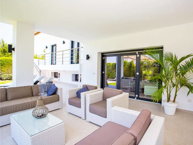 Stylish white and beige outdoor living area with blue trims