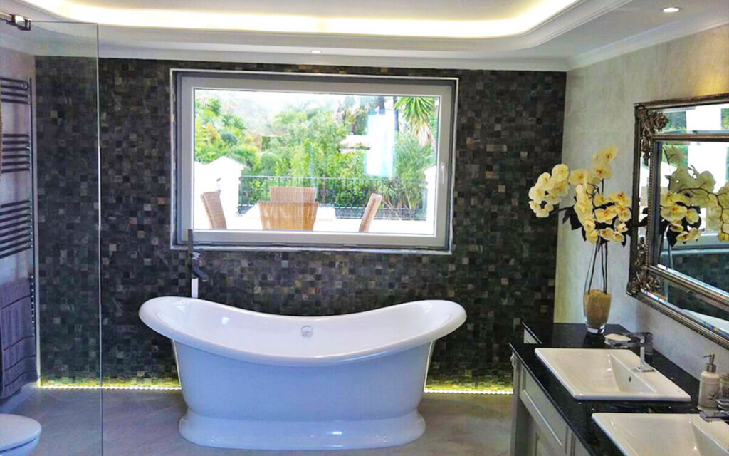Standalone bath with black mosaic tiles