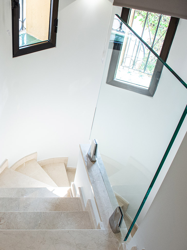 Stylish refurbished stairwell with marble stairs and glass divider