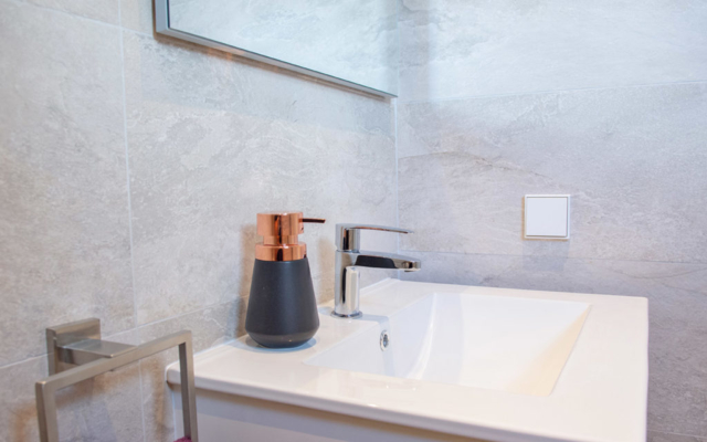 Stylish bathroom grey tiles with white sink