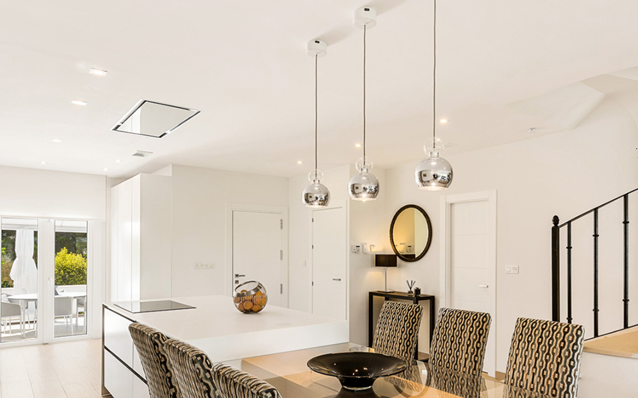 Layered lighting, downlights and pendants in an open plan kitchen