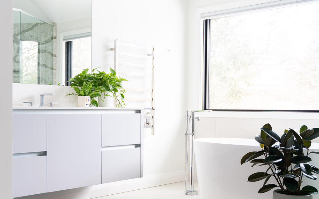 Stylish white bathroom with fresh plants