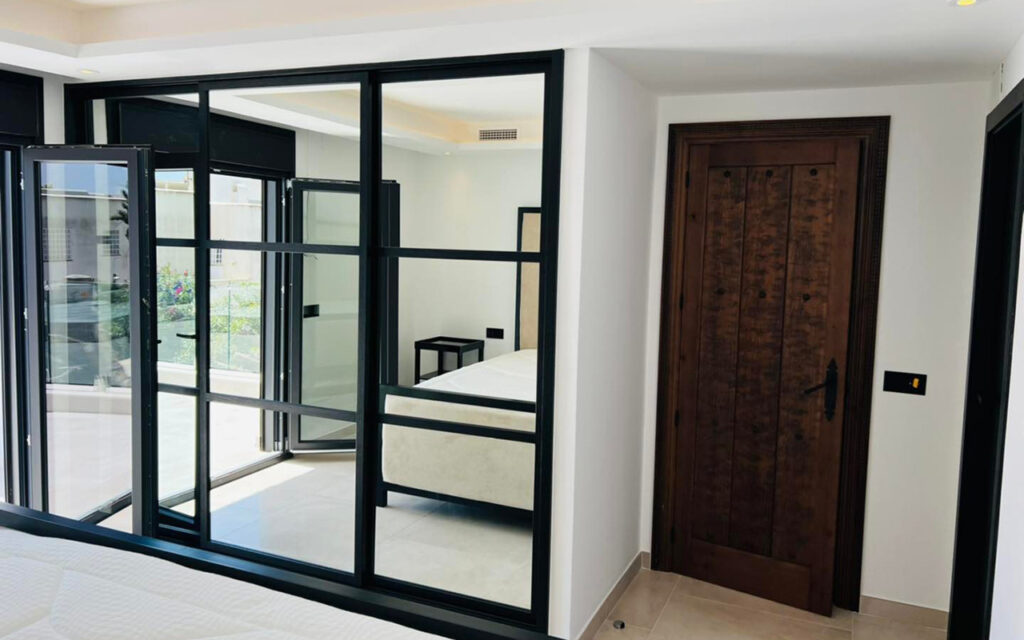 Stylish modern rustic bedroom with bespoke wardrobe with sliding glass doors