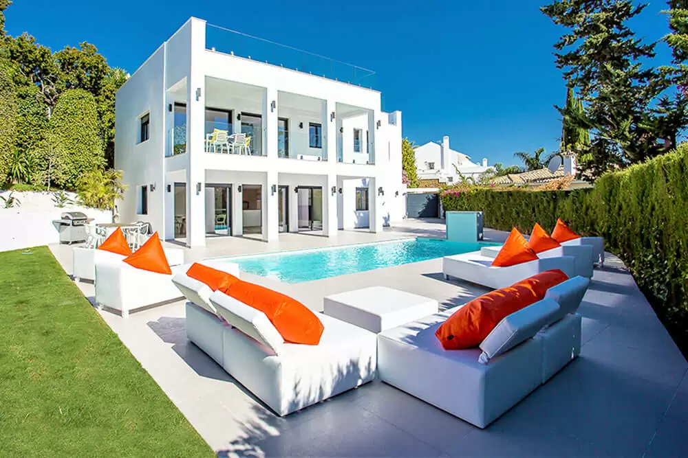 luxury modern white house with pool and sun couches spain