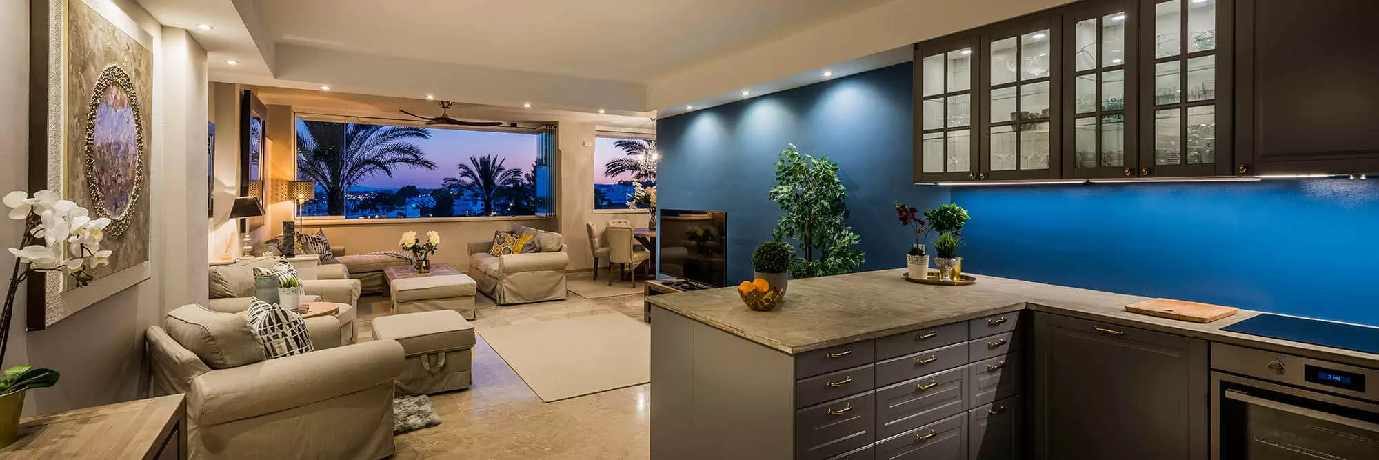 Contemporary open-plan living area featuring a kitchen, lounge, and large windows with views.