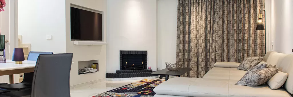 Refurbished living room with fireplace and built in television
